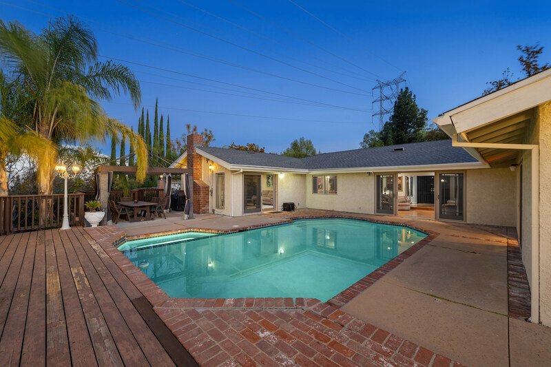 casa al atardecer con alberca iluminada