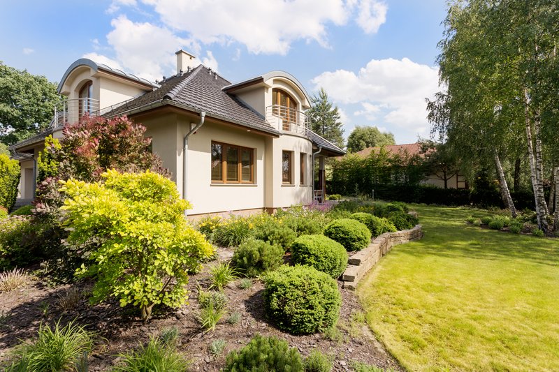 Toma de una casa independiente moderna con un gran jardín verde.
